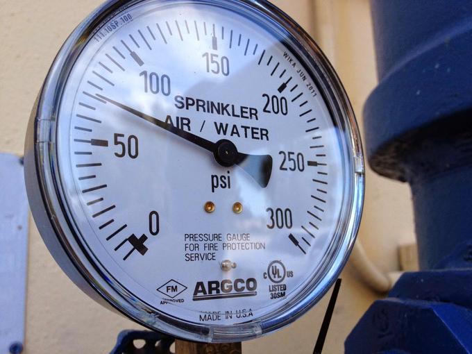 Pressure gauge on a fire protection sprinkler riser reading air and water pressure