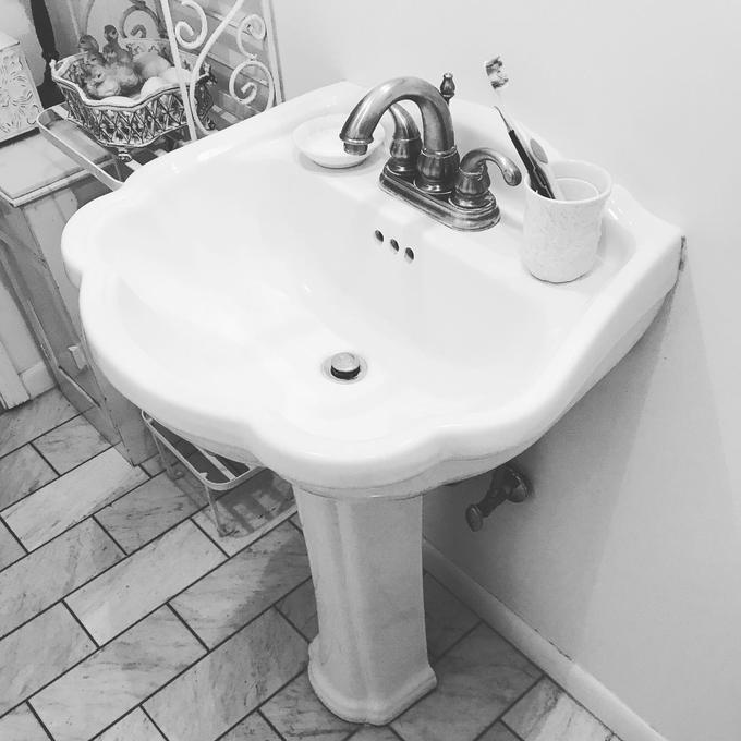 Pedestal sink and two handle faucet installed in a tiled Tampa bathroom