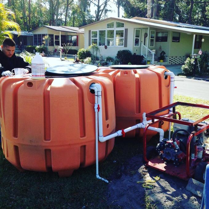 Two new polyethylene septic tanks plumbed together with PVC outside a manufactured home in Tampa